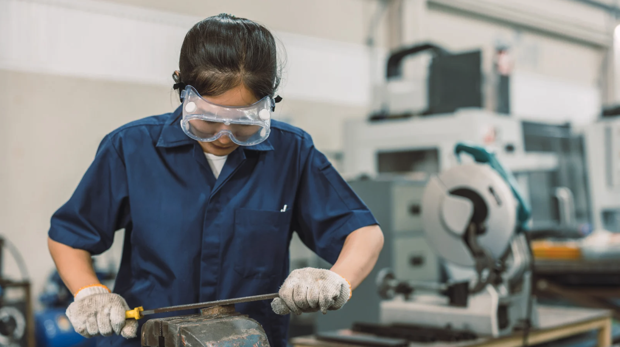 Vocational student working with tools and safety goggles in a workshop